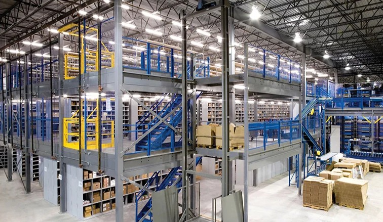 Multi-tier industrial mezzanine floor installed over existing shelving units to double storage capacity
